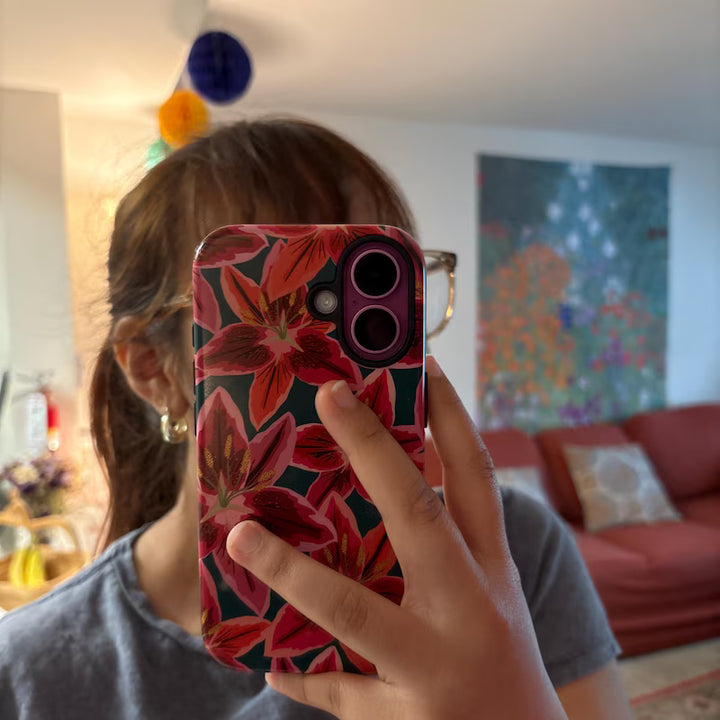 Person holding a phone with a floral case in a living room setting